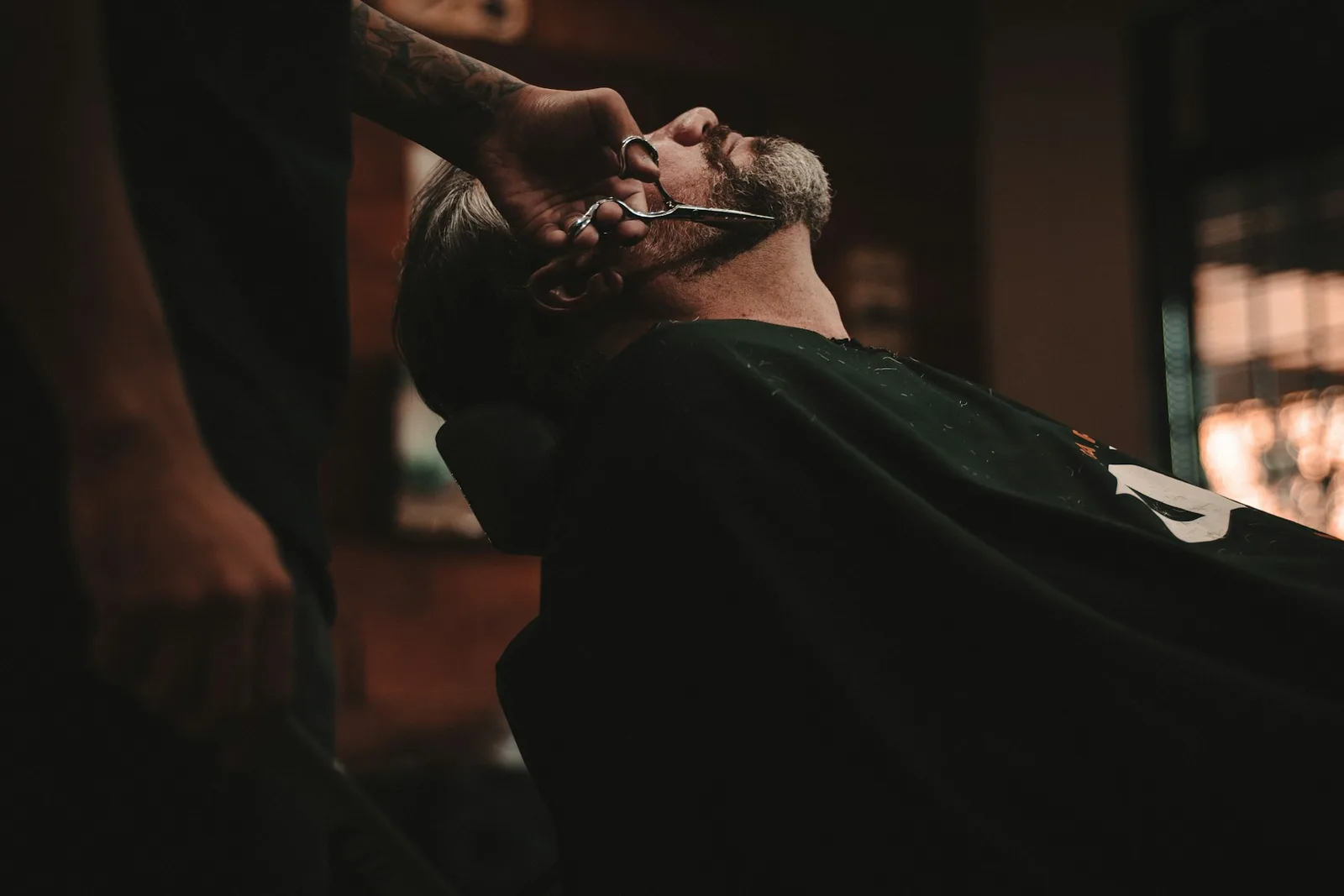 A relaxed beard trim in a warmly lit barbershop — stock photography for this design concept